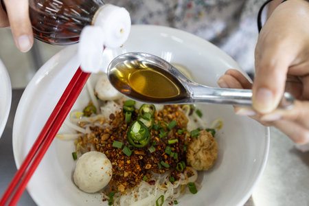 Hand of woman holding Thai sauce used as a condiment,prepared from fermented anchovies and...