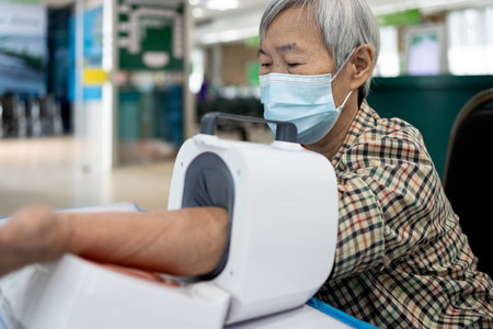 Asian senior people check blood pressure disease,old elderly using digital blood pressure meter...