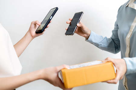 Hand of schoolgirl scanning QR code pay for service to delivery employee,contactless transactions,cashless society,internet payment purchases on cell phone,technology,safe and easy payment conceptの写真素材