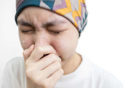 Asian child girl covers her head with a cloth,lady suffering from disease of Acute leukemia cancer,Depressed stressed female patient crying feeling tired and in pain from cancer chemotherapy treatmentの写真素材