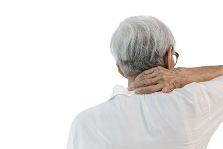 Back view,Senior woman suffering from neck pain,disease of cervical spondylosis,old elderly touching nape or scruff,muscle tension,injury in occipital bone,problems of the neck joints,cervical spineの写真素材