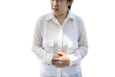Asian office worker has a stomach ache,belly pain,discomfort in the abdomen,indigestion,gastritis,gastric ulcer,digestive disorders,dyspepsia,abdominal gas,colic,bloating,problems of digestion of foodの写真素材