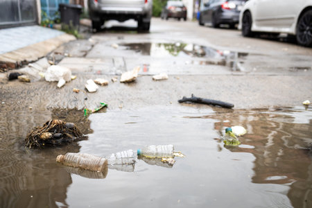 Garbage and dirty water,lot of rubbish scattered all over the street after heavy rains and...