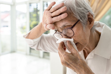 Asian senior woman had nosebleed,epistaxis,stop blood wipe her nose with tissue paper,touches...