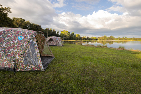 Sisaket,Thailand-November 8,2021:Camping tents for rent in National park for tourists,campsite of Pha Mo E Dang,outdoor camping with tents in nature,riverside camping ground,travel on vacation,holidayのeditorial素材