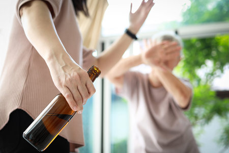 Drunken caregiver beating senior woman at nursing home,holding bottle of alcoholic drink,physically...