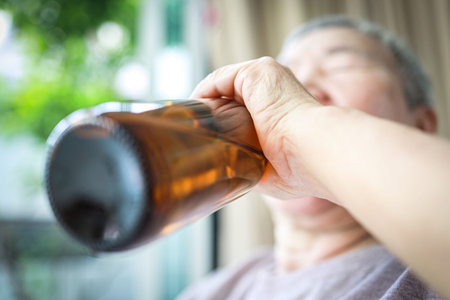 Elderly people with alcoholic drink,drunken,asian senior woman drinking beer from bottle,suffering...