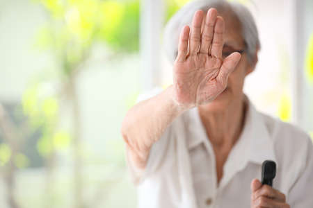 Old elderly woman making stop gesture with palm,campaign against family domestic violence,asian senior people raise hand to show sign,stop violence against women,physical abuse,human rights violationの写真素材