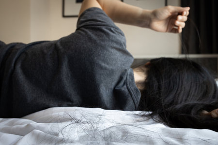 Asian woman pulling her hair with her fingers,mental health problems,brain system,female patient with trichotillomania disease,hair-pulling disorder,hair loss,health care and medical conceptの写真素材