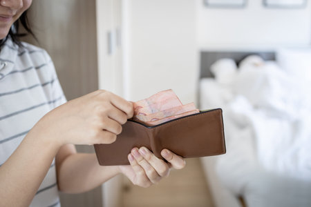 Teenager girl taking cash out of her mother's wallet while mother was asleep in bedroom at...