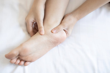 Hands of girl massage her foot,pain under ankle bone, disease of Flat Foot,inflammation of muscle and tendon between foot and ankle from Tibialis Posterior Dysfunction or Problem of Plantar Fasciitisの写真素材