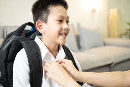 Excited, child boy dress up for first day of school,mother checking the neatness of clothes,happy elementary student ready to go to school with school bag on his back,back to school,lifestyle conceptの写真素材