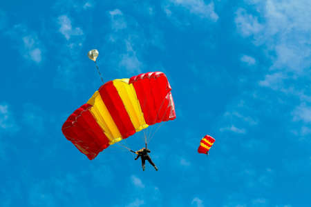 Skydiver and colorful parachute on blue sky background.の素材
