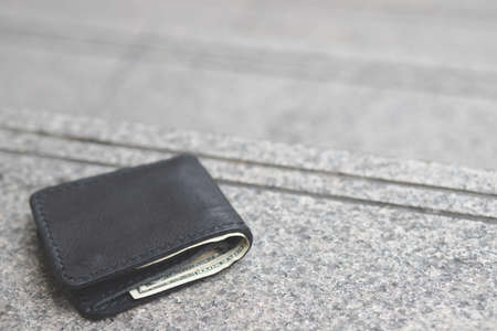 The black wallet fell on the public pathの写真素材