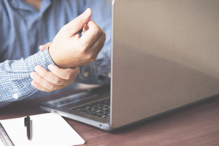 businessman hand working with laptop computer on wooden desk in modern officeの写真素材