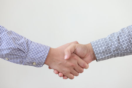 Business people shaking hands, closeup of hands, isolated on whiteの写真素材