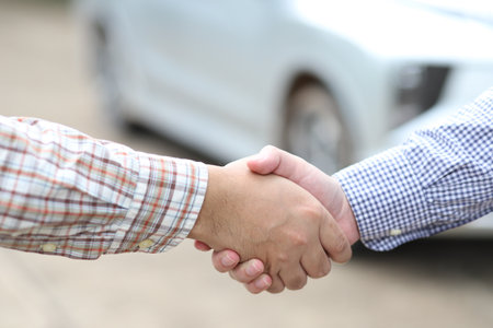 Handshake of business partners after signing a contract with car background.の写真素材