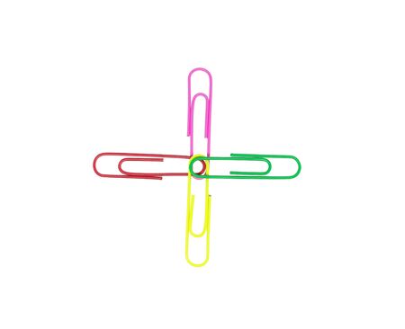 Four colorful paper clips in plus sign. Decorative paper clips in pink, yellow, green, and red colorsの写真素材