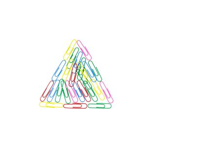 Multicolored paper clips in the form of a triangle on white background. Decorative paper clips in pink, yellow, green, red and blue colorsの写真素材