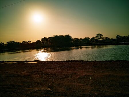 Beautiful view when sunset comes. Beautiful sunset sky and silhouette trees with reflected light on the waterの写真素材