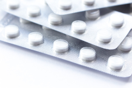 Many white tablets in the package (blister) Background on the topic of illness, health, treatment and medicine.の写真素材
