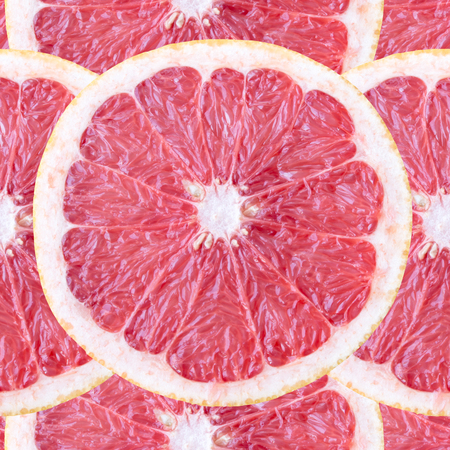 Seamless background with bright slices of pink grapefruit, shot closeup, isolatedの写真素材