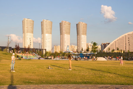 Russia, Moscow - 06 July 2020: Khodynka field, Park and residential area. Summer in the city. People relax in the city park at sunset on a hot day.のeditorial素材