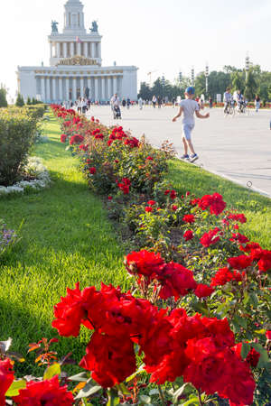 Moscow, Russia - July 26, 2020: Central Pavilion and Central Avenue at VDNKh. Summer day. Flowerbeds are decorated with red roses.のeditorial素材