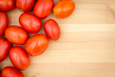 top view of red tomatoes on wooden background, close up, Vertical, copy spaceの写真素材