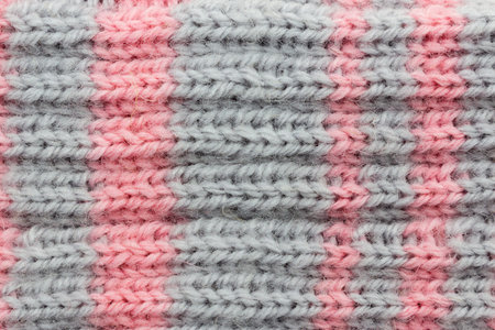Close-up of a canvas knitted in two colors, background. Concept of hobby, light industry, clothing...