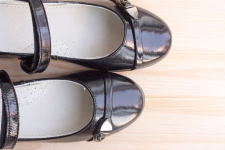 pair of black patent leather shoes on wooden background, copy spaceの写真素材