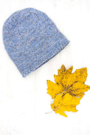 Blue knitted wool winter hat on a white wooden backgroundの写真素材