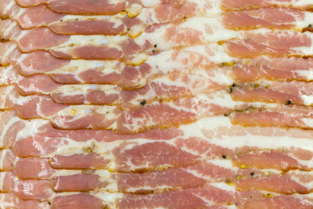 Slices of thin bacon with pepper peas. Food background and texture.の写真素材