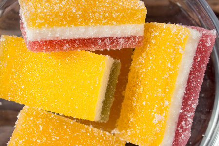 marmalade made of three layers sprinkled with granulated sugar in cubes in a glass plate