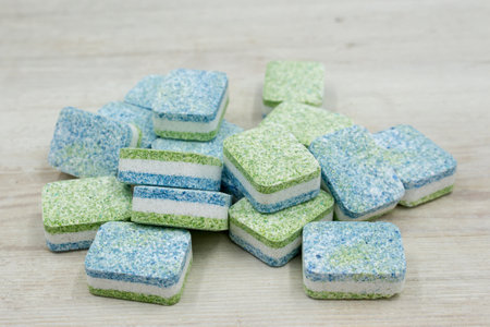 Dishwasher tablets on white wooden background.の写真素材