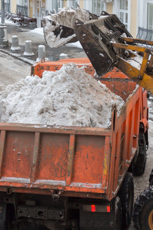 Dirty snow is loaded into a truck for transportation to the snow-melting plant plant.の写真素材