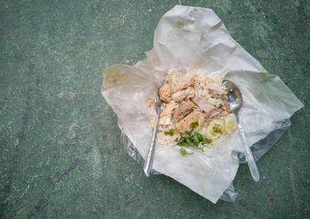 Hainanese chicken rice in plastic paper place on cement floor.の写真素材