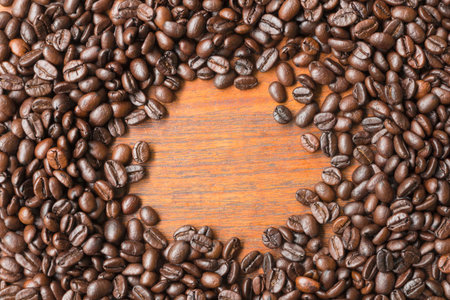 Coffee beans on wooden table with copy space for text or image.