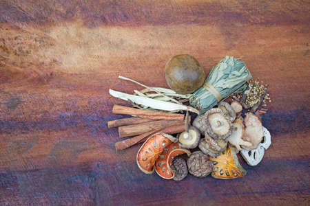 Top view of Dried mushrooms, Dried bael, Cinnamon and Dried herbs or spices on a wooden table, image with copy space for text or image.の写真素材