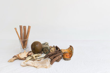 Dried mushrooms, Dried bael, Cinnamon and Dried herbs or spices on a white wooden table, image with...