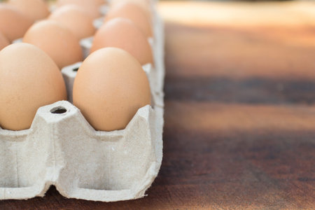 Brown eggs in package on a wooden table, image with copy space.
