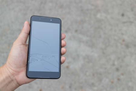 Man holding a Broken Smartphone and touch screen damage broken.の写真素材