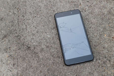 Smartphone mobile fall on the cement floor with touch screen broken.の写真素材