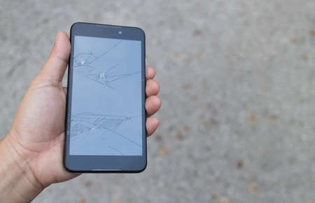 Man holding a Broken Smartphone and touch screen damage broken.の写真素材