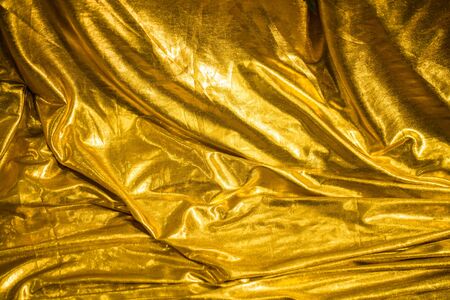 golden fabric abstract background, textile foldsの写真素材