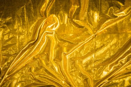 golden fabric abstract background, textile foldsの写真素材