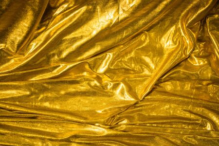 golden fabric abstract background, textile foldsの写真素材