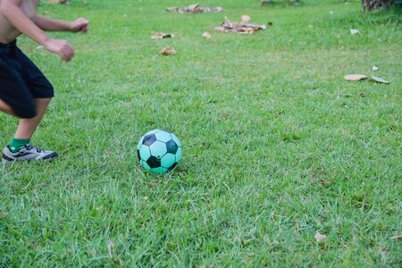 Little Boy playing soccer in the parkの写真素材