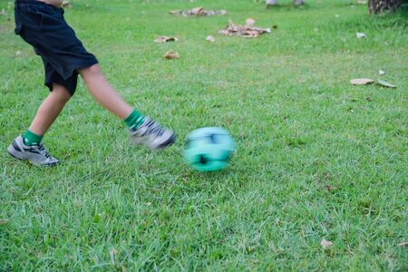 Little Boy playing soccer in the parkの写真素材