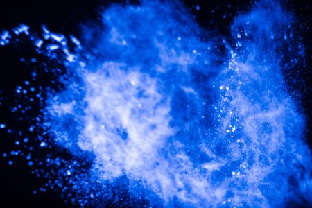Blue powder explosion on black background. Colored cloud. Colorful dust explode.の写真素材